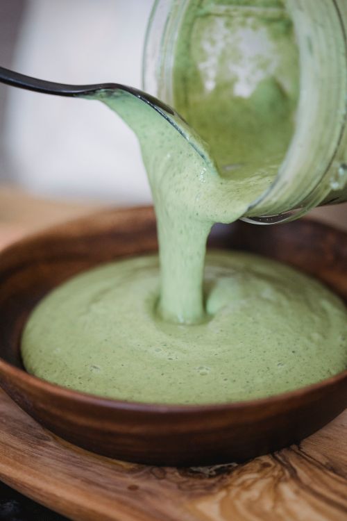 Free Close-up of creamy green smoothie being poured into a wooden bowl. Stock Photo