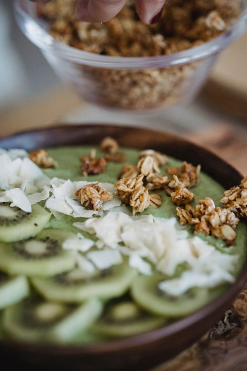 Free Delicious kiwi smoothie bowl topped with granola and coconut flakes, perfect for a nutritious breakfast. Stock Photo