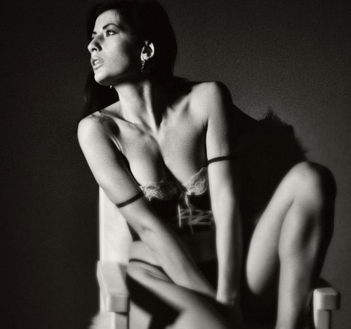 Free Artistic black and white portrait capturing a model in lingerie posing gracefully on a chair. Stock Photo