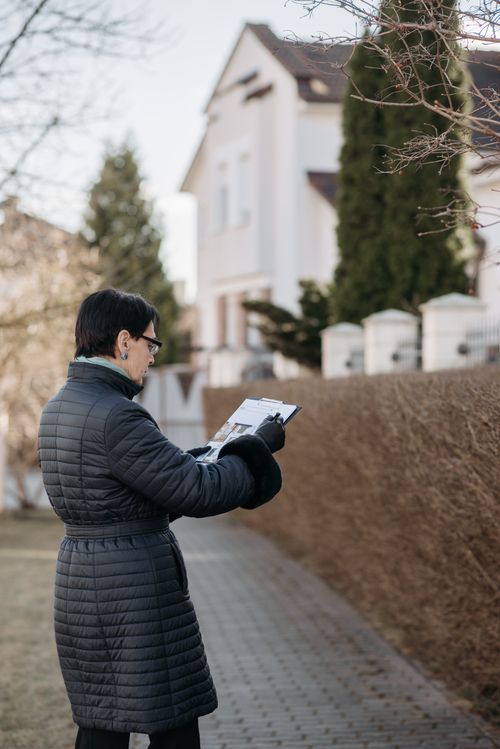 Free A real estate agent examines house plans while standing outside. Stock Photo