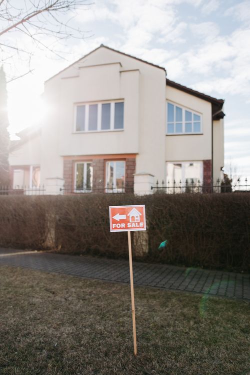 Free Exterior view of a suburban house with a clear for sale sign. Perfect for real estate promotion. Stock Photo