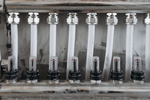 Detailed view of a network of pipes with valves in a metal framework, emphasizing industrial mechanics.