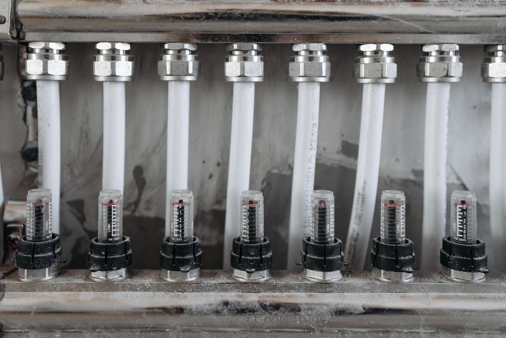 A row of white pipes fitted with flow gauges in an industrial manifold