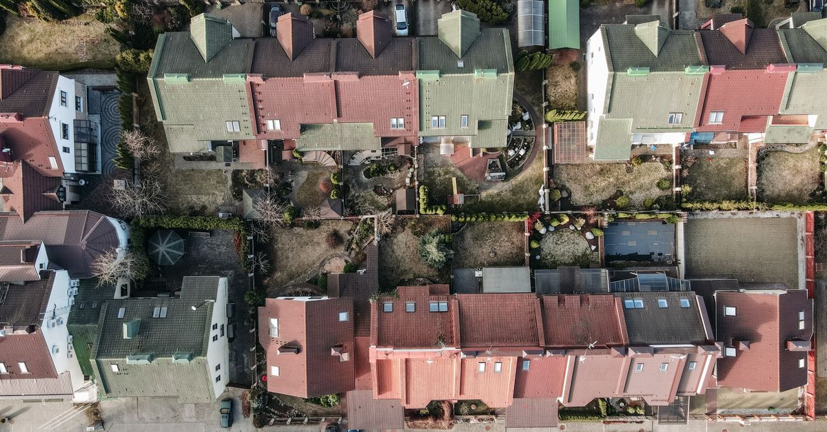 High-angle view of a suburban residential area with colorful rooftops and gardens.