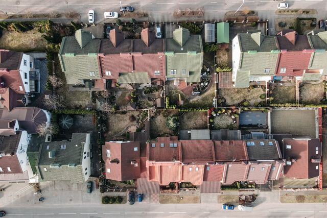 Vue aérienne d'un quartier résidentiel avec toits colorés et jardins, point de vue typique d'un télépilote drone immobilier à Bordeaux