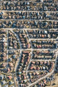 High-angle aerial view of a dense suburban neighborhood with organized streets and houses.