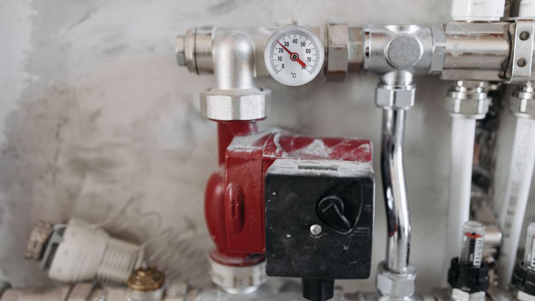 A pressure gauge fitted to a run of steel water pipe