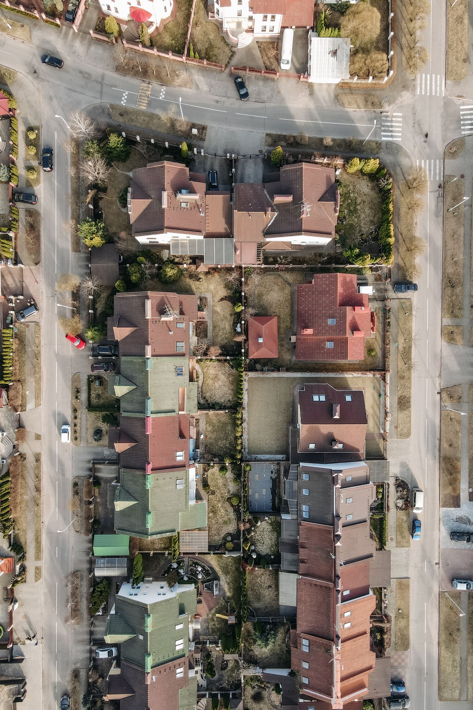 Drone view of a suburban neighborhood with homes, streets, and urban planning layout.