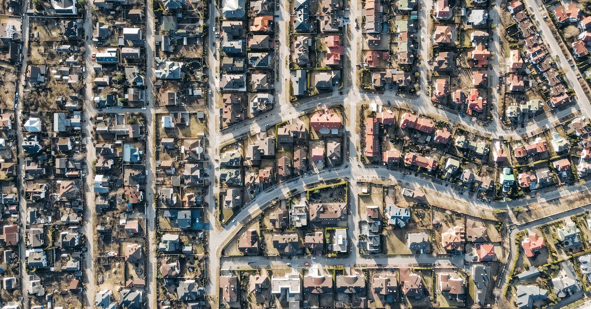 Aerial view showcasing a suburban residential neighborhood with neatly arranged houses and curving roads.