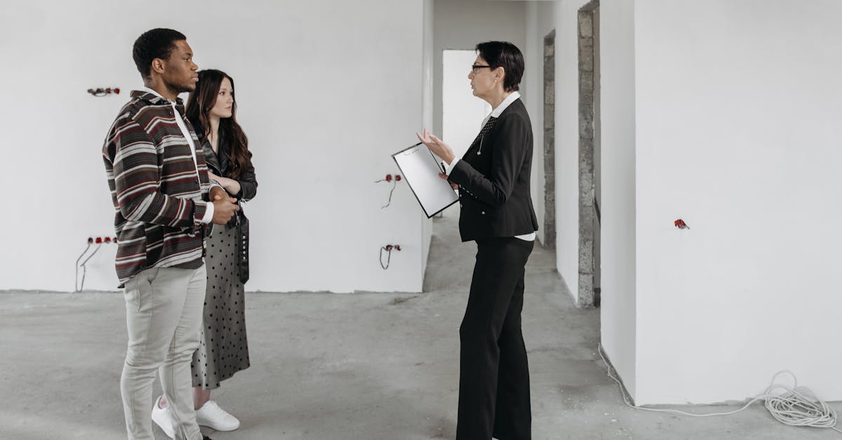 Photo by Pavel Danilyuk Real estate agent showing a house to a couple in a newly built home interior.