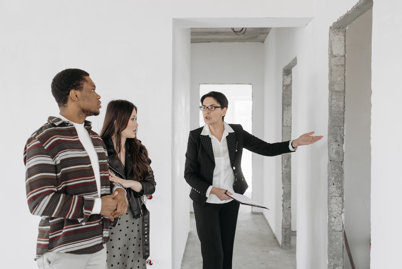 Real estate consultant discussing a residential property with a couple during a site visit