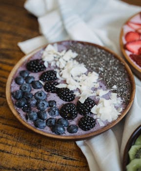A nourishing smoothie bowl with blackberries, blueberries, coconut flakes, and chia seeds.