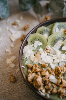 Delicious kiwi and granola breakfast bowl garnished with coconut flakes for a healthy start.