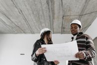Two architects examining blueprints