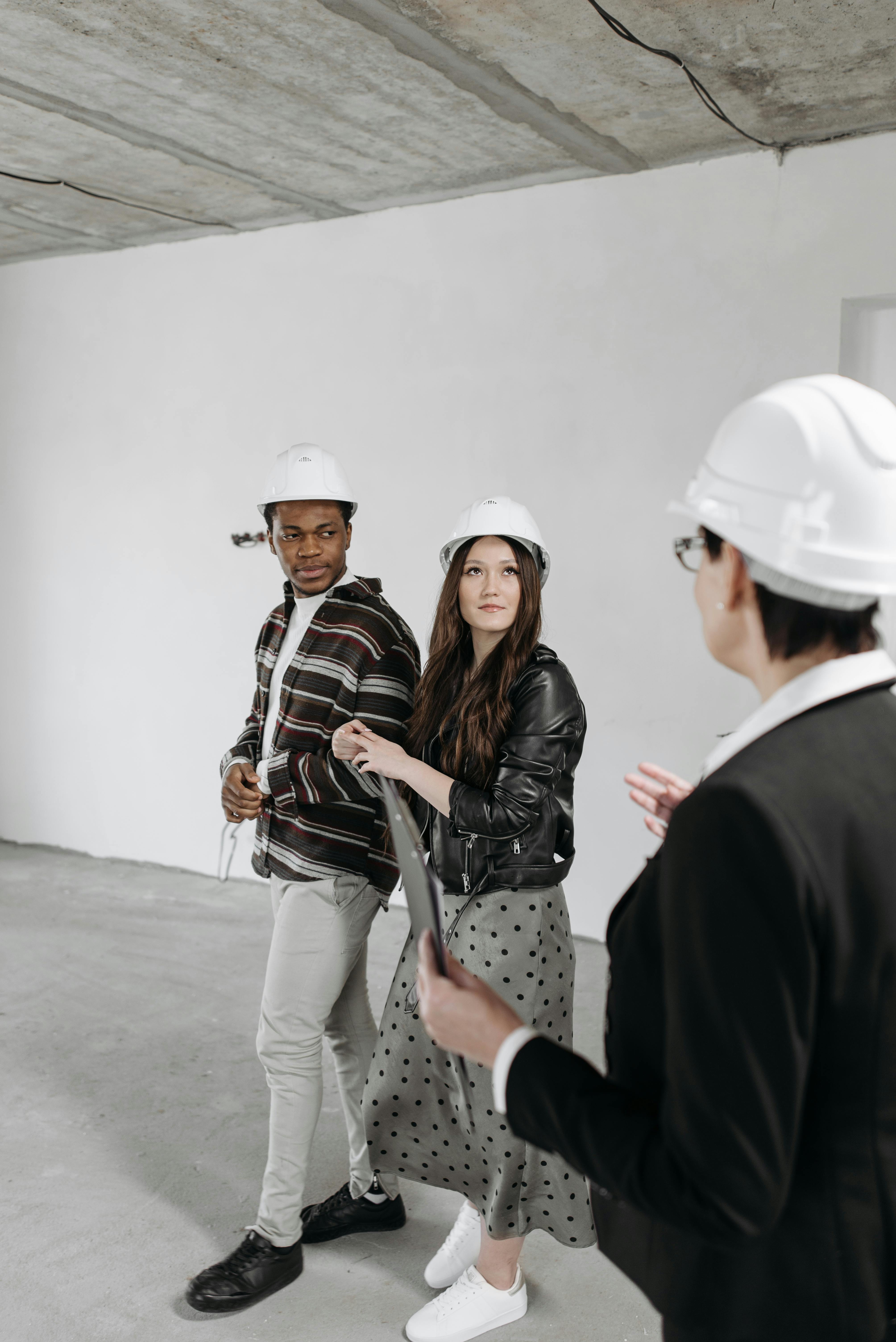 seller and clients in helmets in house room