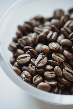 High-quality image of roasted coffee beans in a glass bowl, perfect for coffee-related themes.