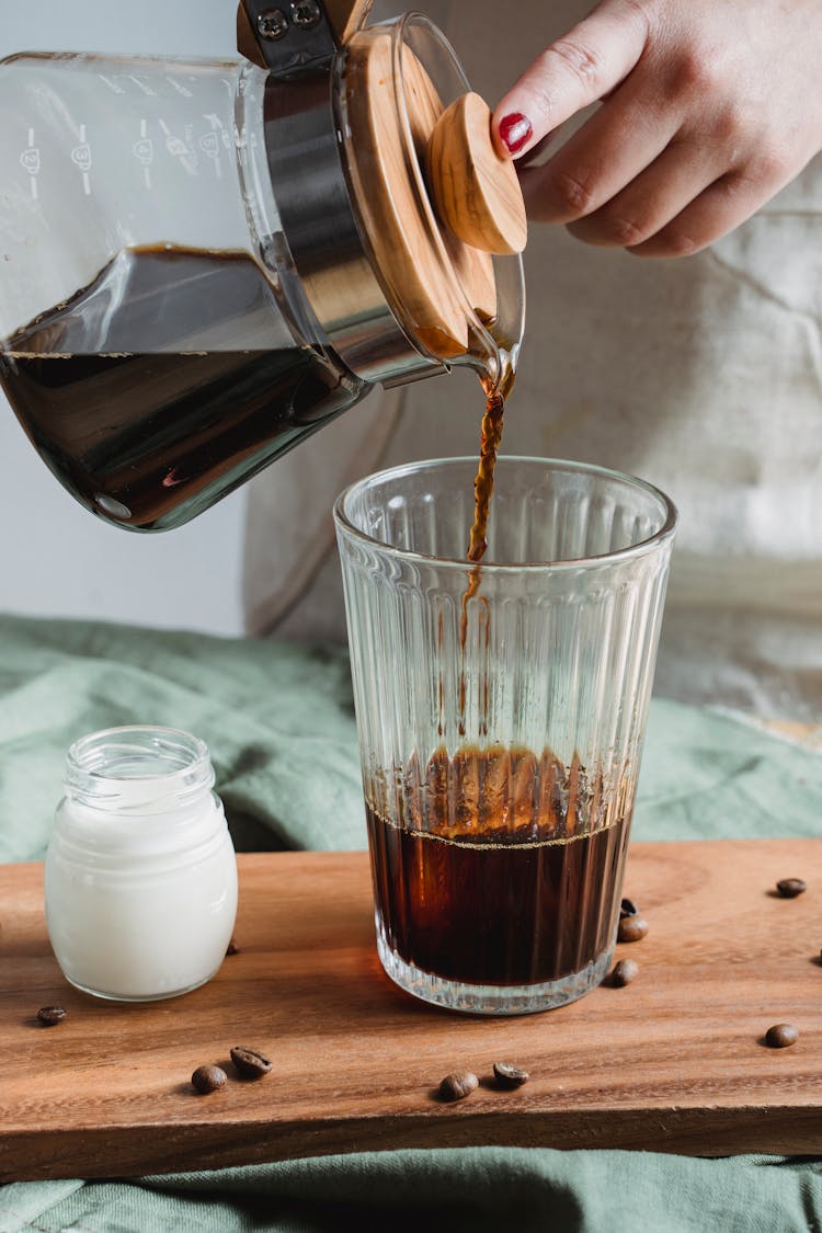 Pouring Black Coffee On Clear Glass