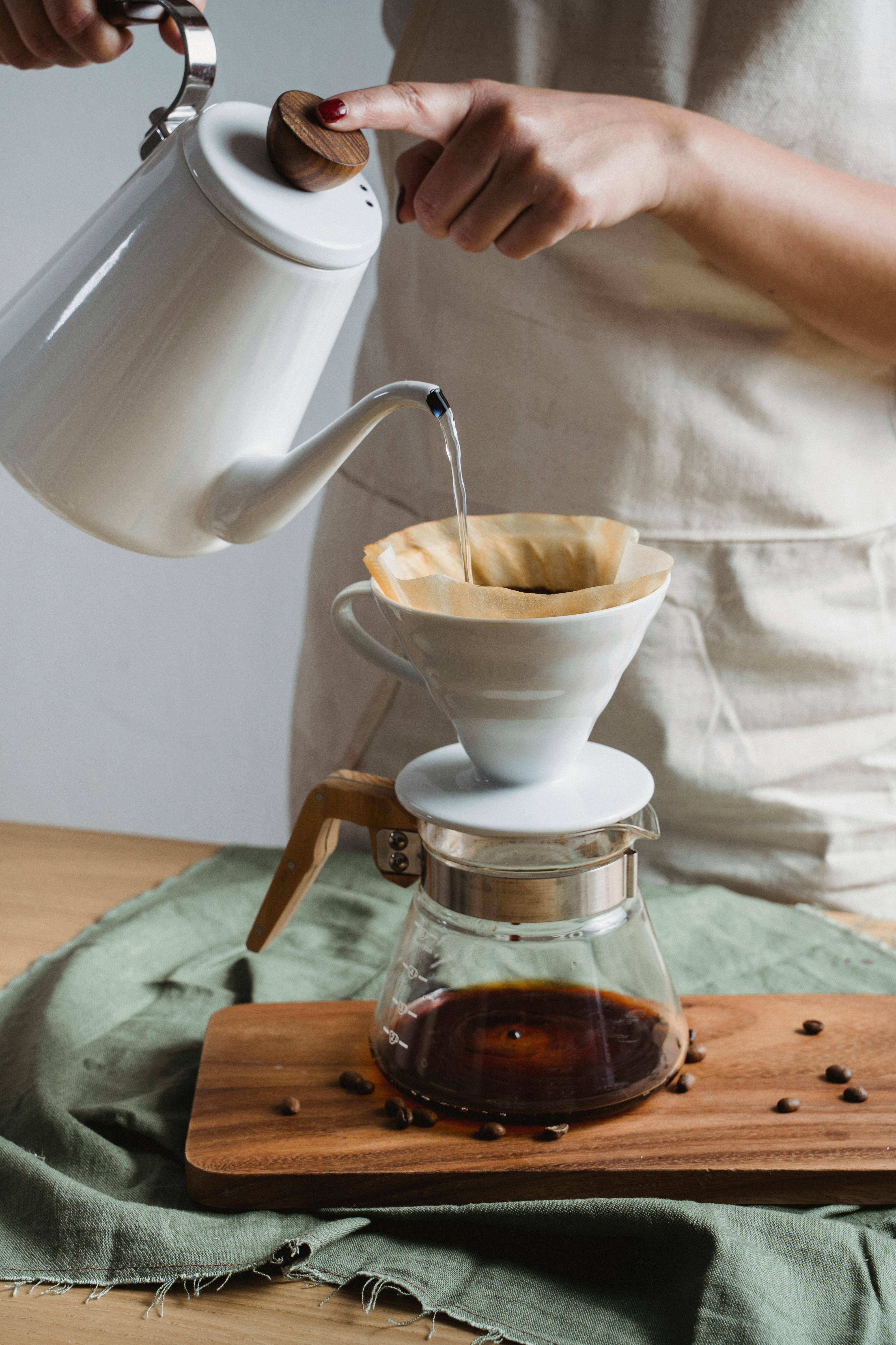 Hand Pouring Water on White Ceramic Cup with Cone by Nicola Barts