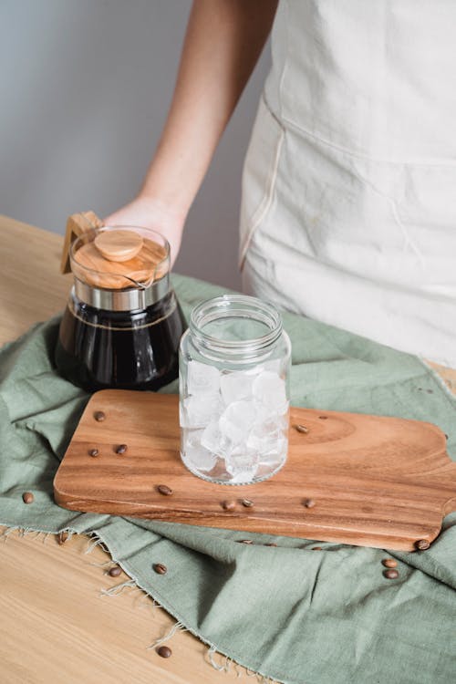 Ice Cubes on Clear Glass Jar on Brown Wooden Board