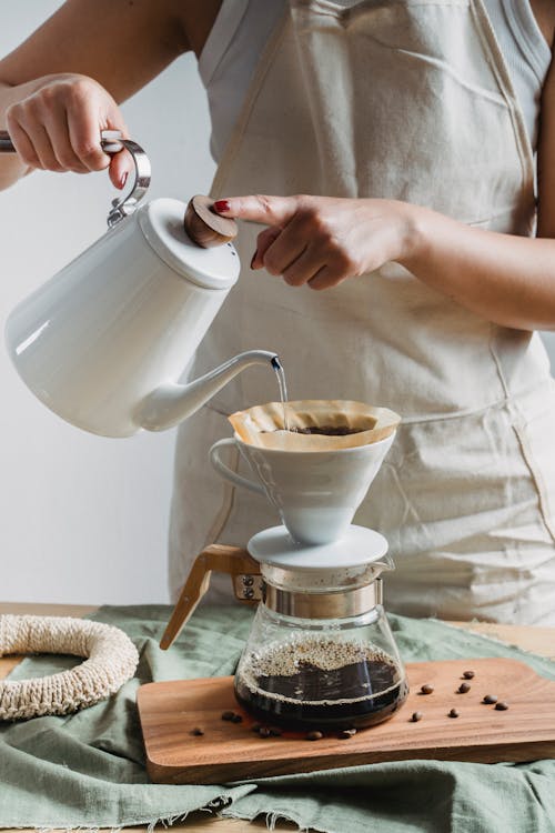 Free Close-Up Shot of a Person Pouring Hot Water in a Coffee Pot Stock Photo
