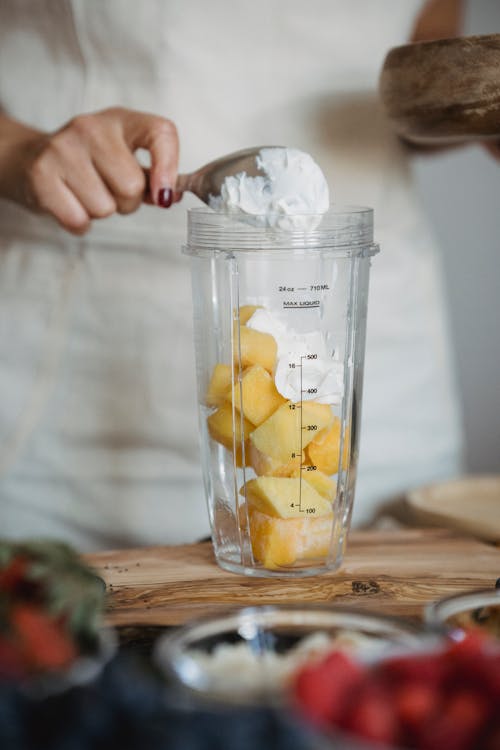 Woman Preparing a Smoothie in a Blender 