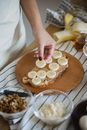 Hand Arranging Slices of Banana on Bread