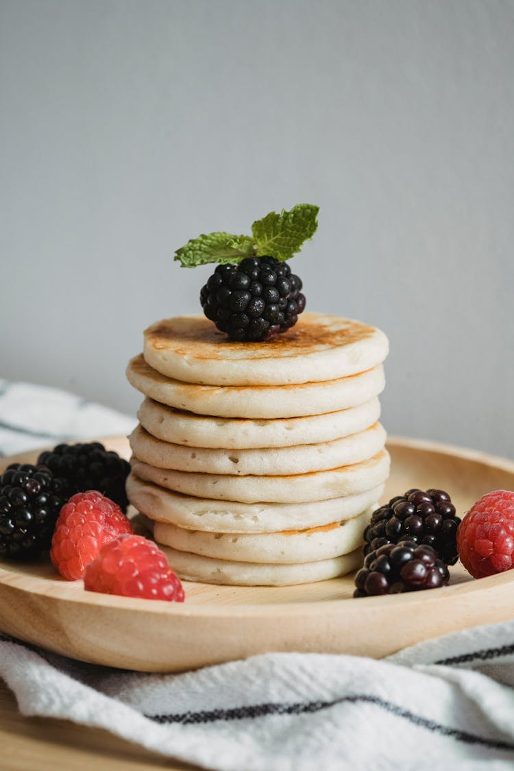 Stack Of Pancakes With Raspberries And Mint Leaves