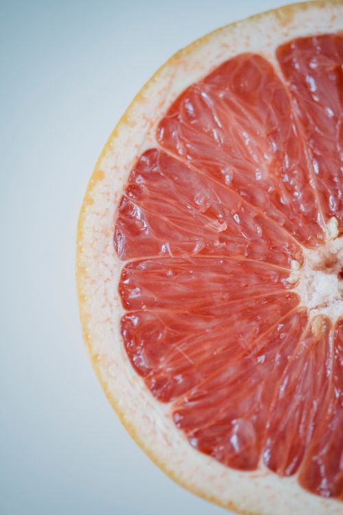 Free Close-up of a juicy grapefruit slice showcasing vibrant pulp and texture. Stock Photo