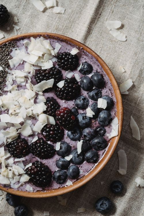 Free Delicious smoothie bowl topped with blackberries, blueberries, chia seeds, and coconut flakes. Stock Photo
