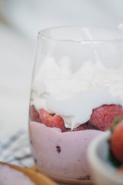 Fresh Raspberries with White Cream on Top in Clear Glass