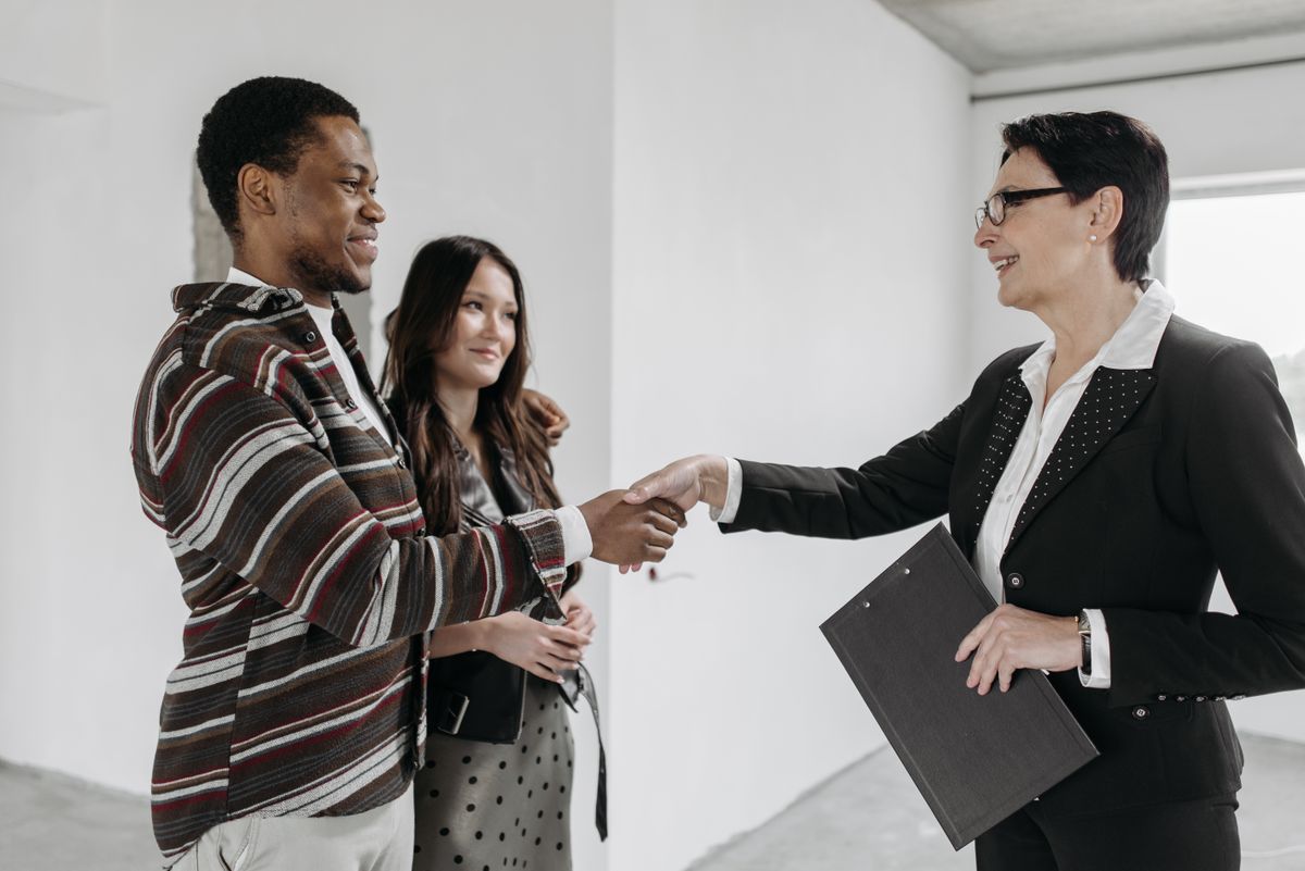 A real estate agent shaking hands with a client after closing on a home