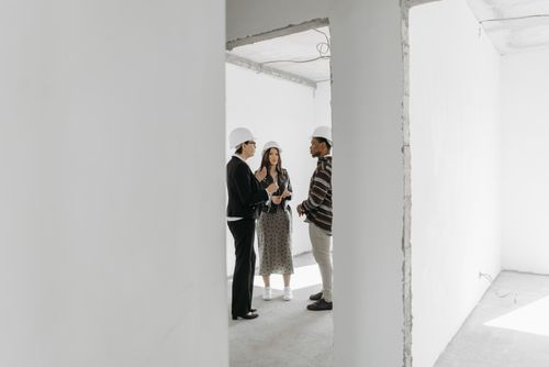 Free Group discussing potential property purchase inside an unfinished building. Stock Photo