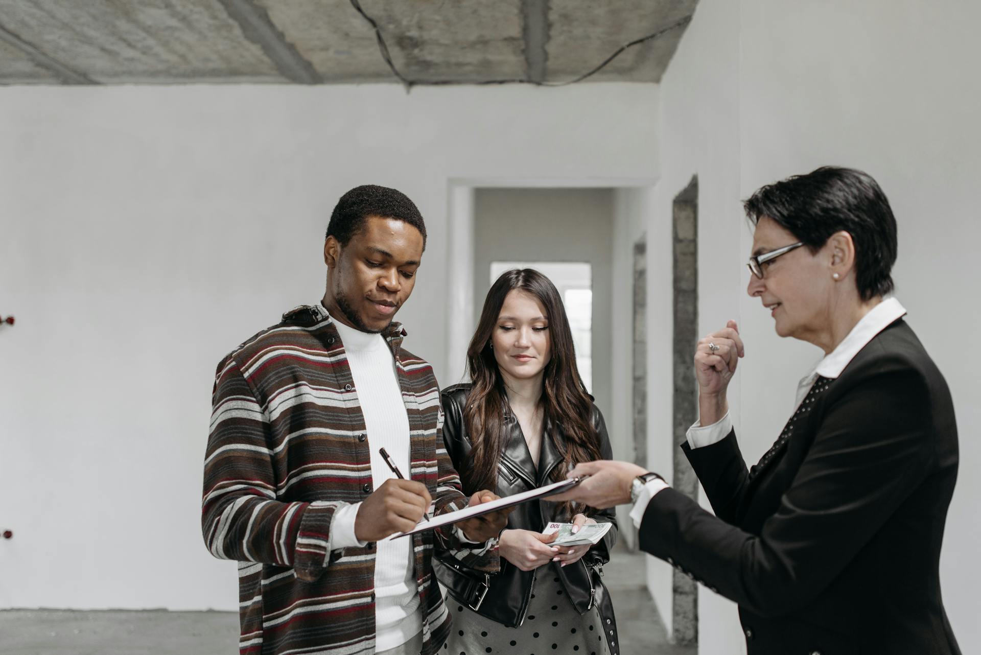 A Man Signing the Document the Agent is Handing