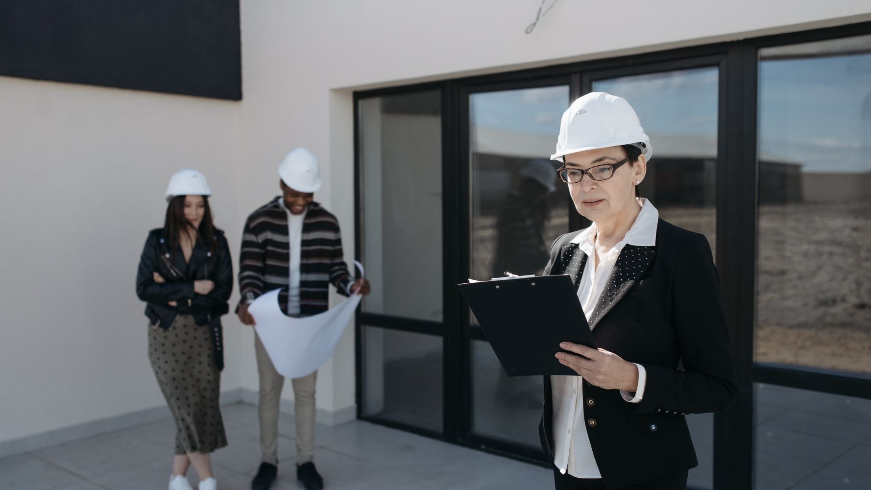 Facility managers reviewing an annual maintenance contract and building plans in Dubai
