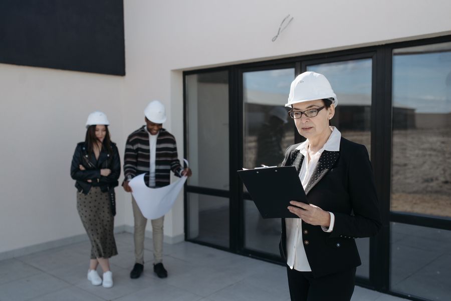 Arquiteta com capacete a acompanhar obra em conjunto com o cliente