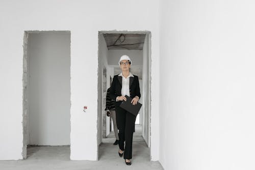 A Woman in Black Blazer Walking at the Doorway