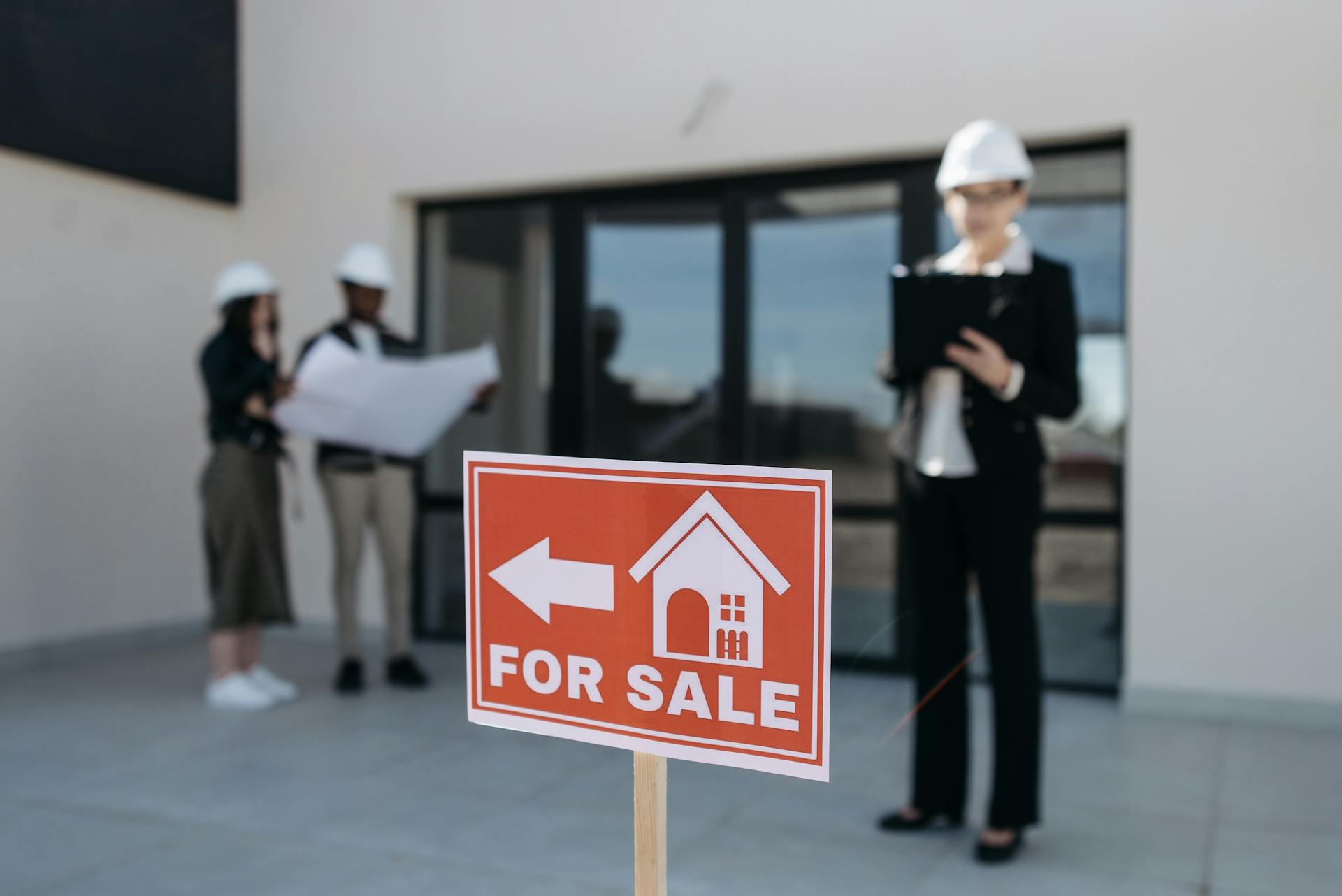 Three real estate professionals inspecting a property for sale with a focus on the business aspect.