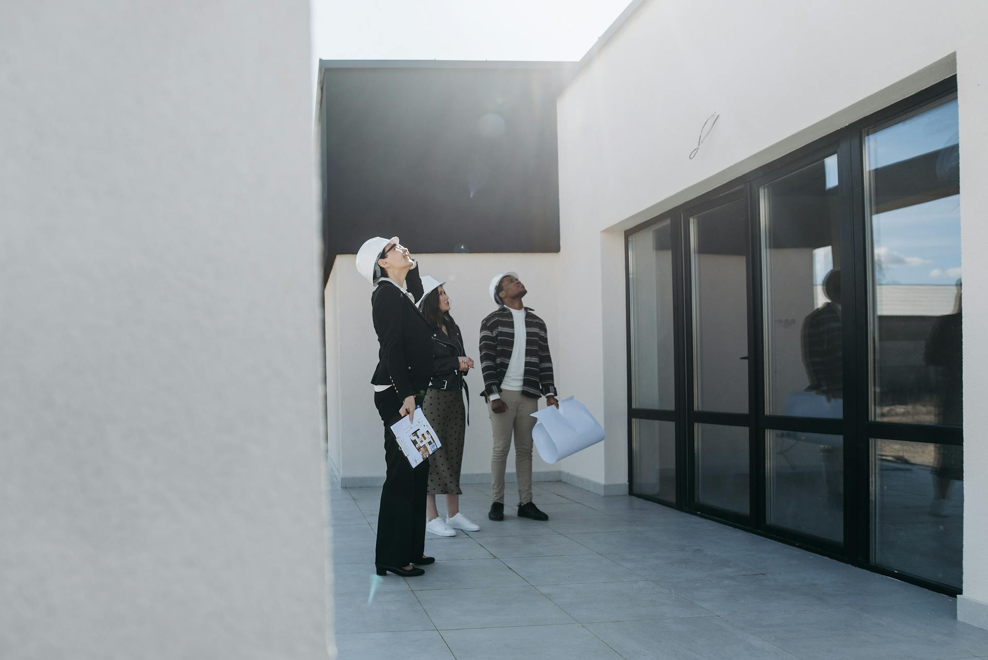 Group of real estate agents assessing a modern building during the day.