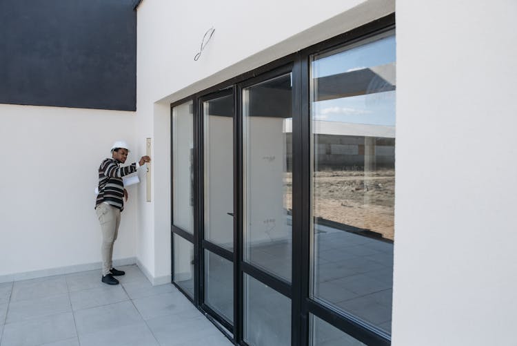 An Architect Checking The Walls Of A House