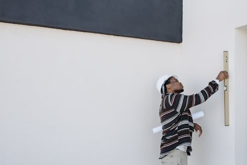 A Man Wearing Hard Hat Checking the Walls