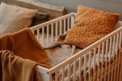 A warm, inviting nursery displaying a stylish crib adorned with textured pillows and a plush blanket.