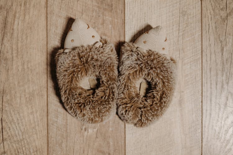 A Fury Slippers On A Wooden Surface