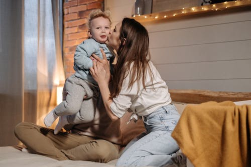 A Woman Kissing a Boy on the Cheek