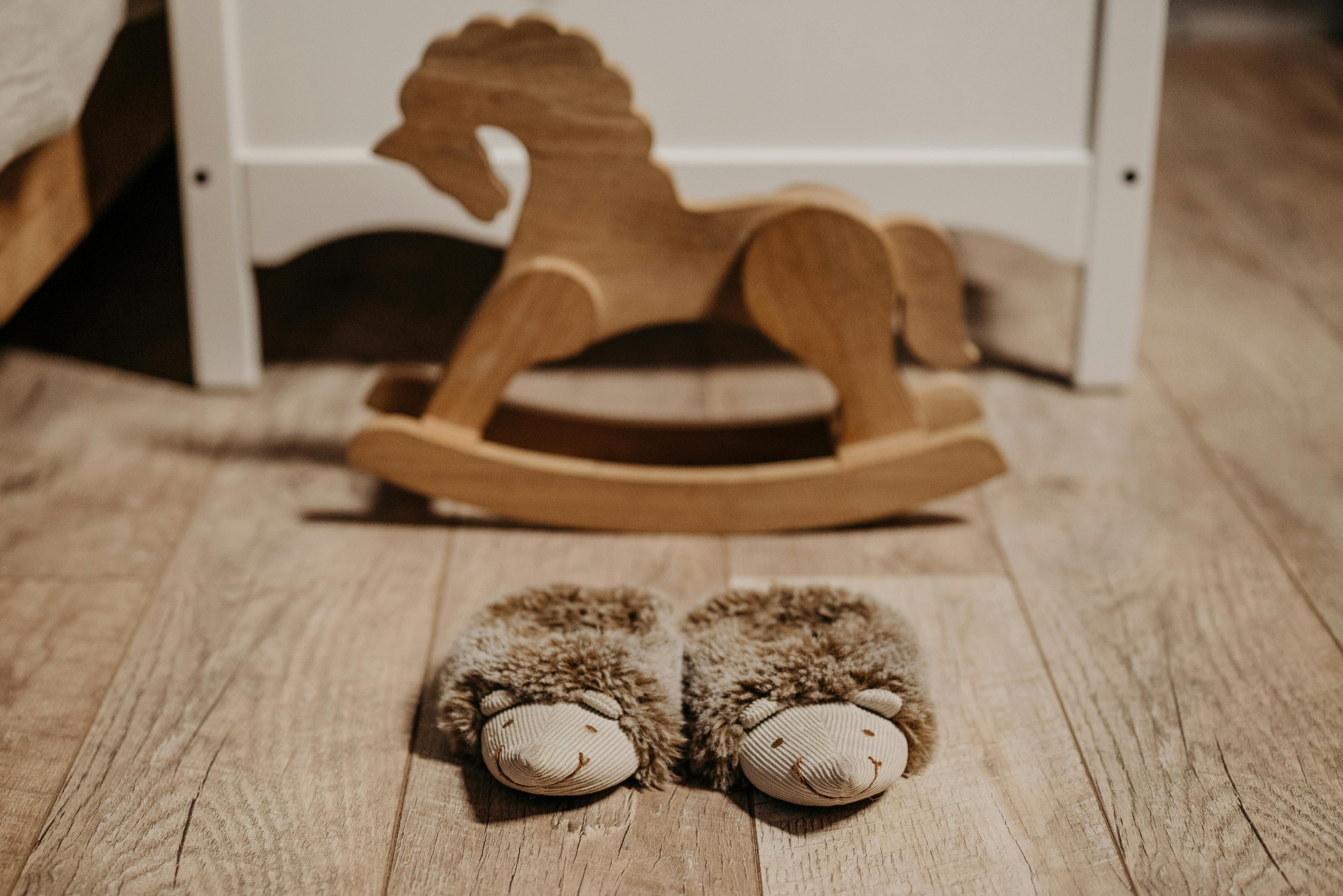 brown furry slippers and a wooden rocking horse on the floor