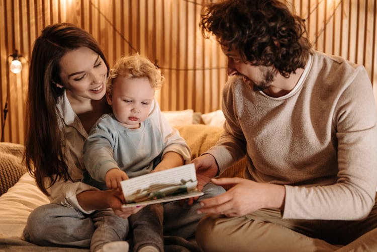 Parents Reding A Book For Baby