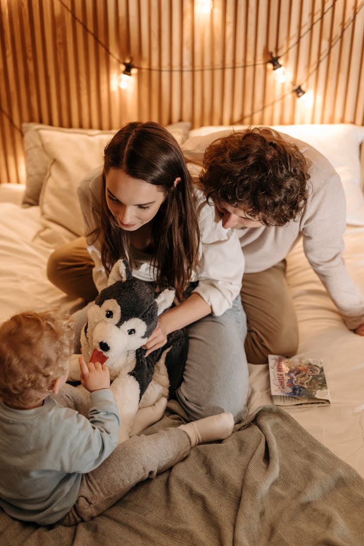 Mom Holding Dog Stuffed Toy In Front Of Child