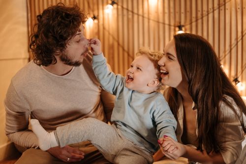 Free Happy family bonding time with parents and child laughing indoors. Stock Photo
