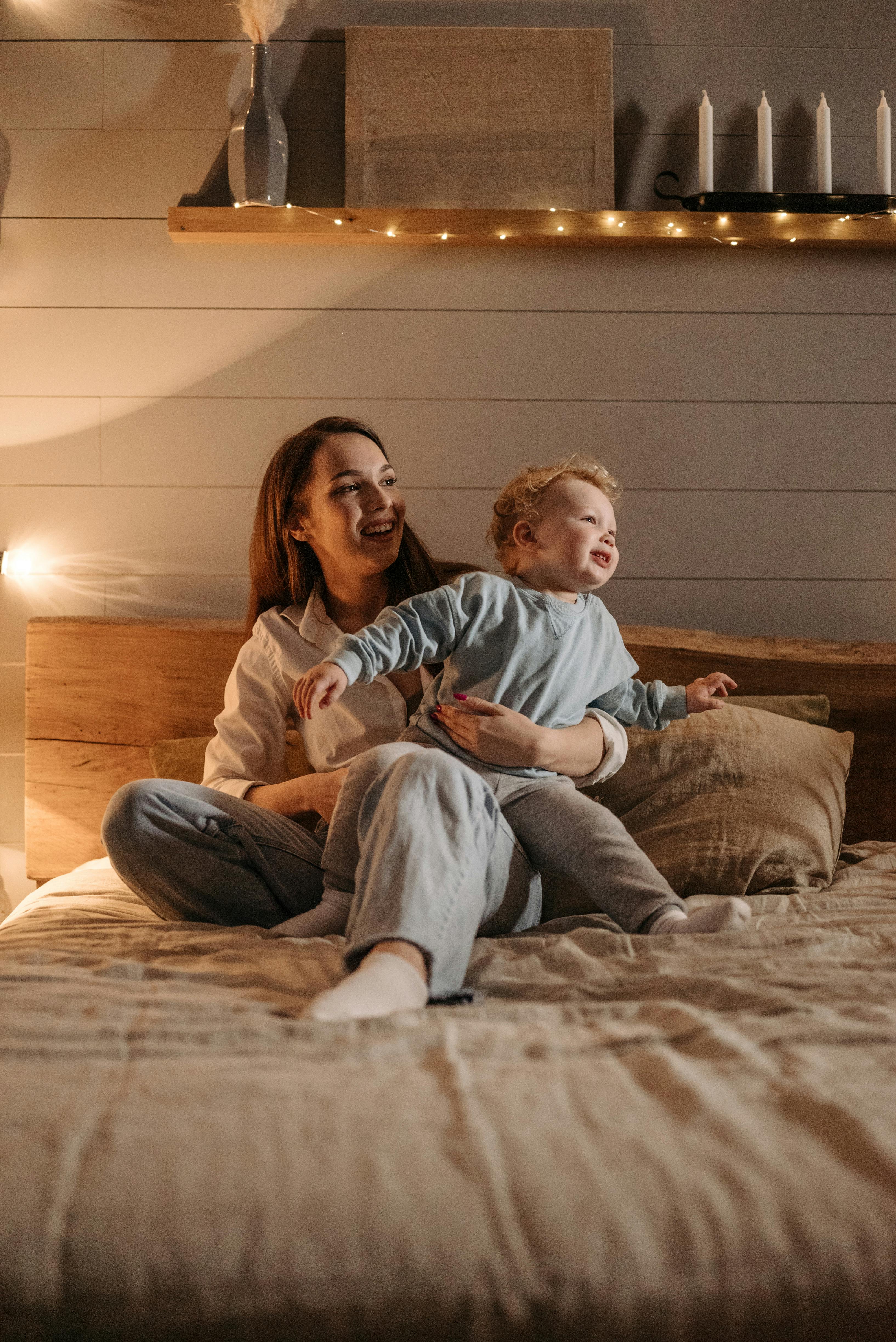 woman sitting on bed with child