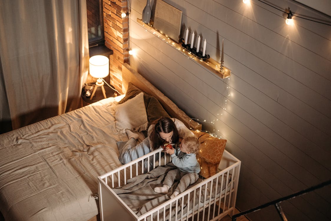 Free Mother Taking Care of Little Son in Bedroom Stock Photo