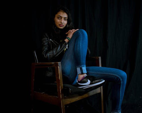 Mulher Usando Jeans, Sentada Na Poltrona De Madeira Marrom